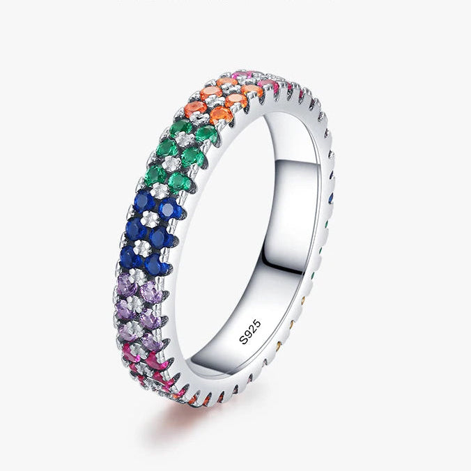 Silver ring with colorful gemstones on a white background